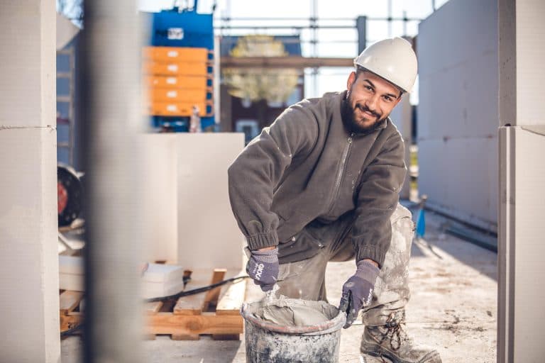 Bauarbeiter, der kniend arbeitet